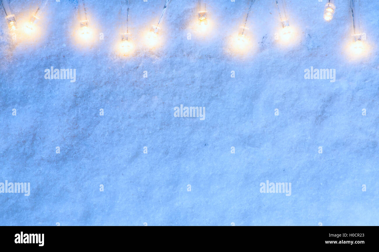 Arte le luci di Natale sul blu sullo sfondo di neve Foto Stock