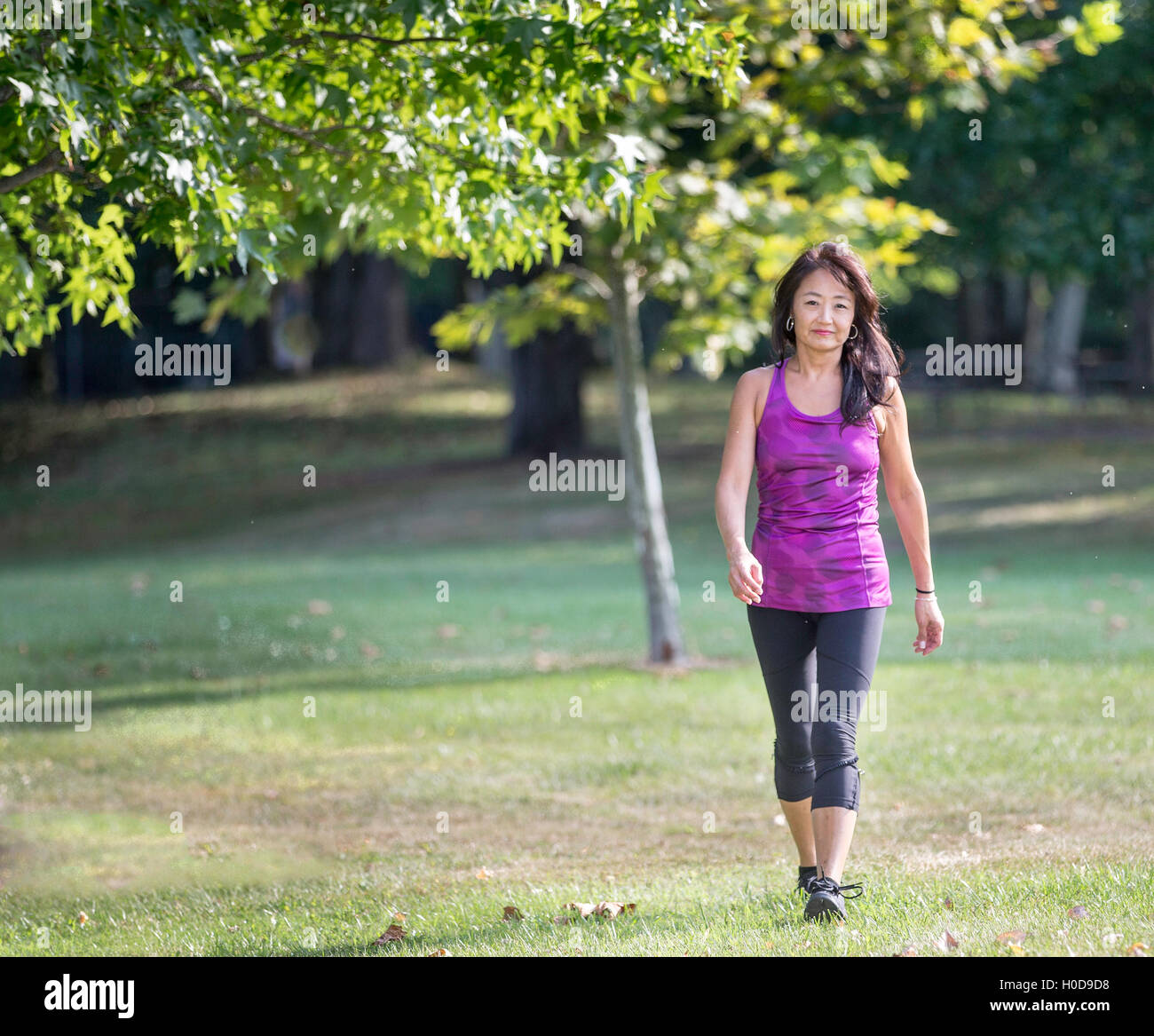 Asian donna americana a camminare in un parco Foto Stock