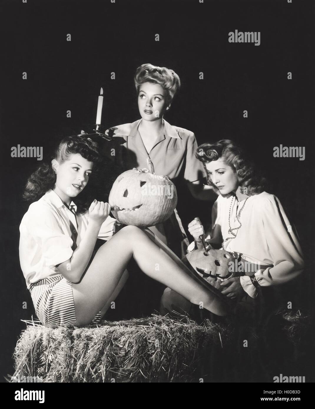 Tre donne in un granaio carving zucche di notte Foto Stock