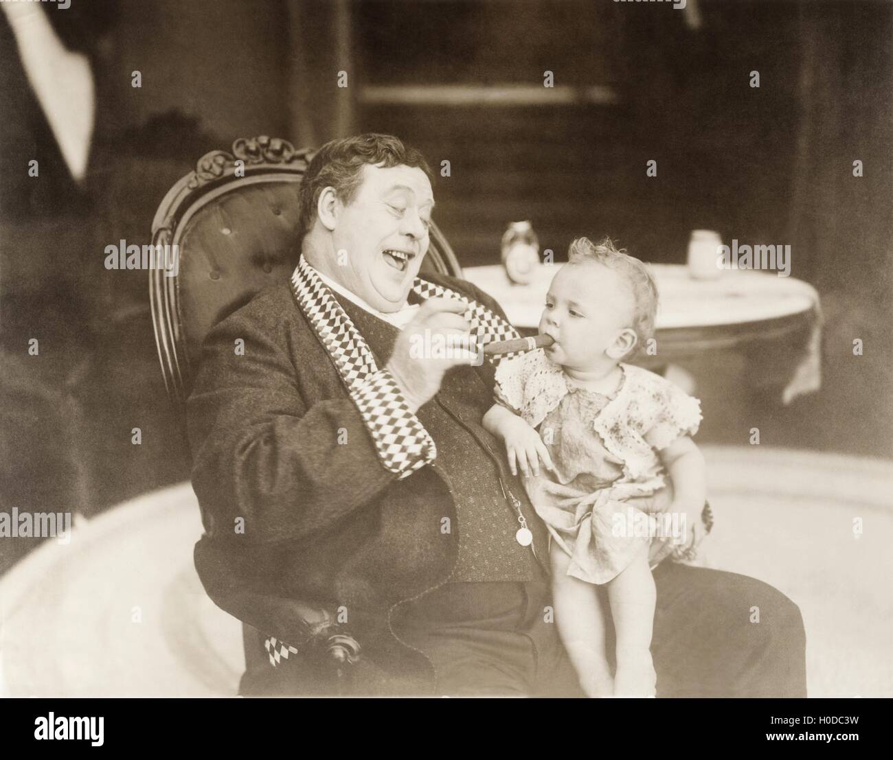 L'uomo ridere baby fumatori di sigaro Foto Stock