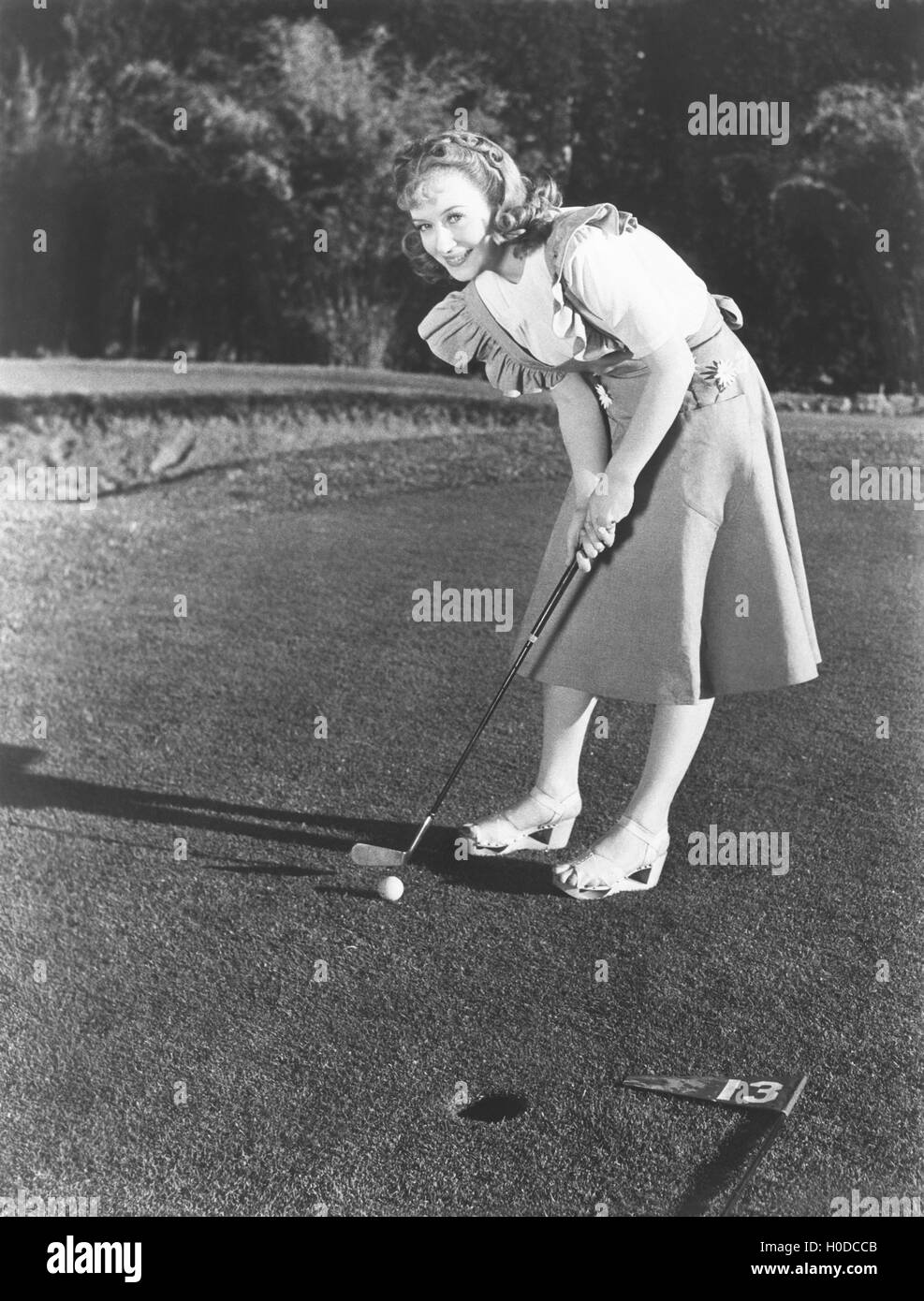 Giocatore di golf femminile in procinto di prendere un colpo Foto Stock