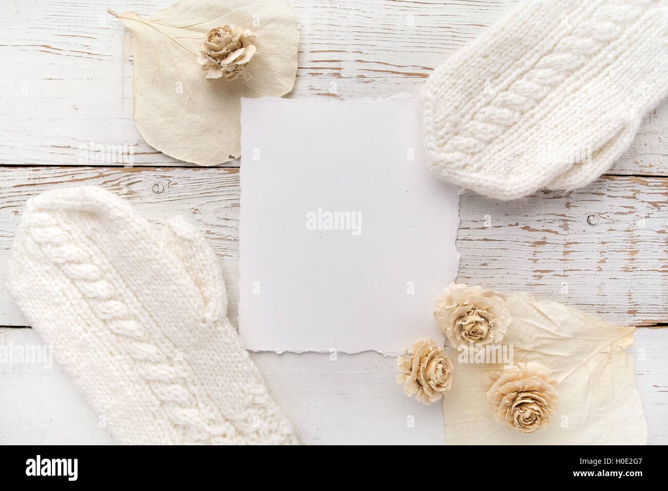 Scheda vuota con i guanti bianchi e fiori su sfondo di legno Foto Stock