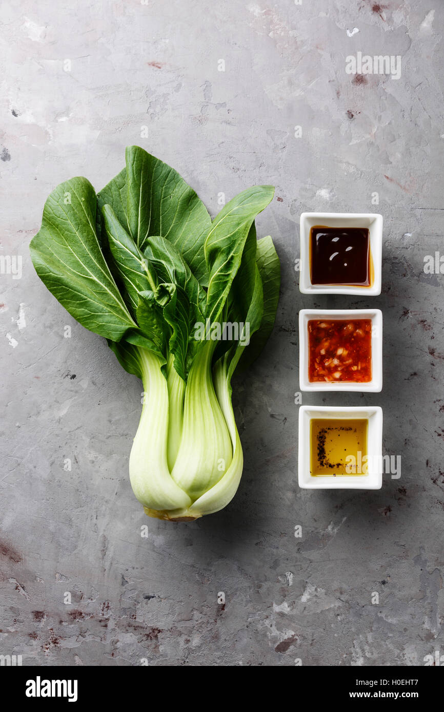 Fresh pak choi cavolo e diverse salse sul cemento grigio sfondo di pietra Foto Stock