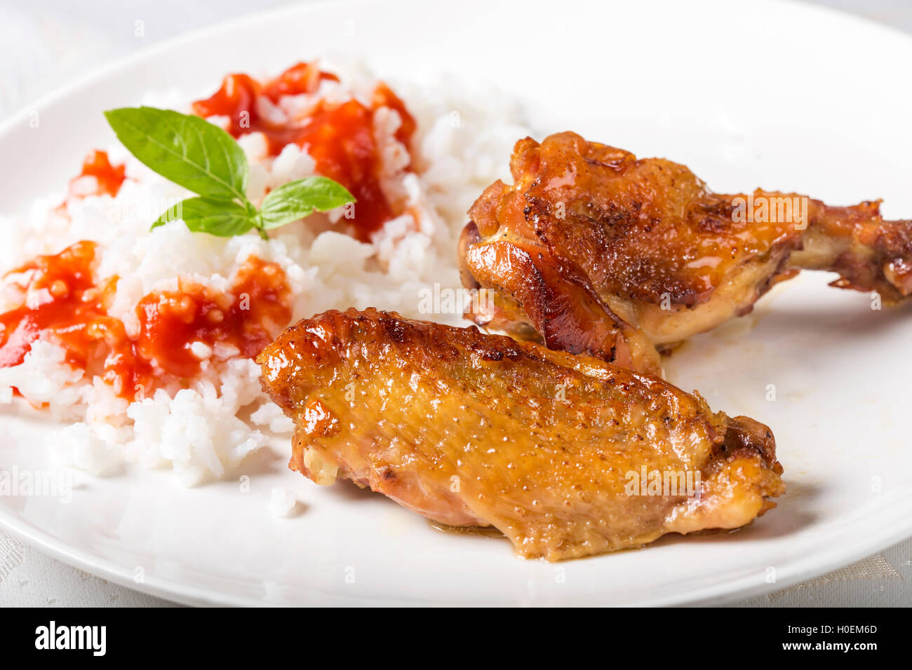 Buffalo ali di pollo con riso e salsa di pomodoro sulla piastra bianca Foto Stock