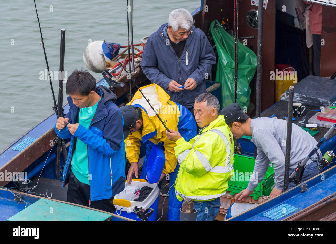 Gruppo di pescatori su una barca in preparazione per un viaggio di pesca. Foto Stock