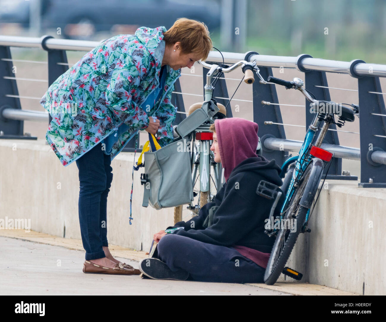 Signora aiutando i giovani senzatetto dando loro del cibo. Foto Stock