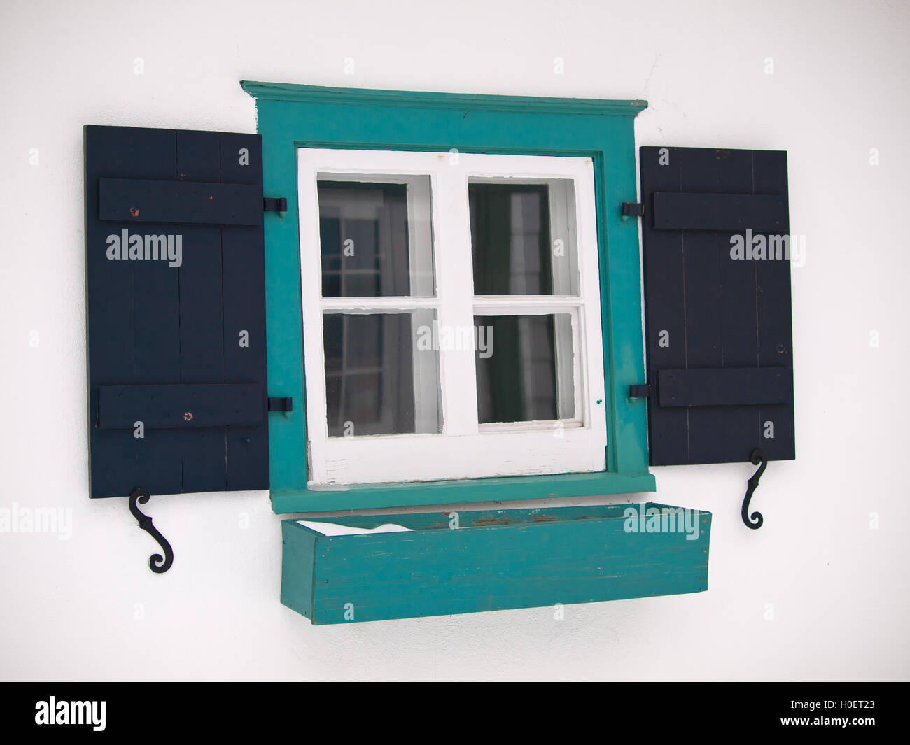 Vecchia finestra con persiane functionnal oltre il muro bianco Foto Stock