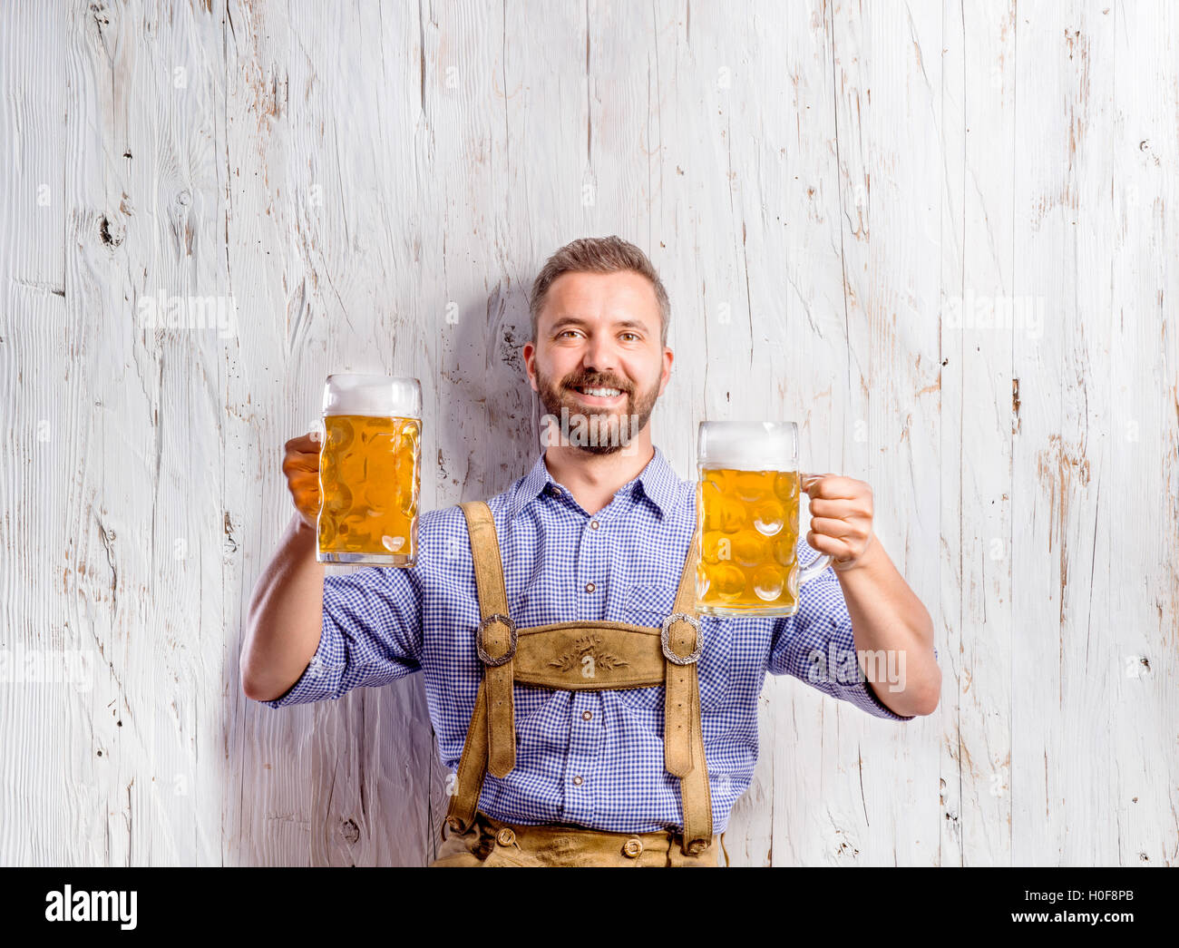 Uomo in tradizionali bavaresi vestiti con due birre Foto Stock