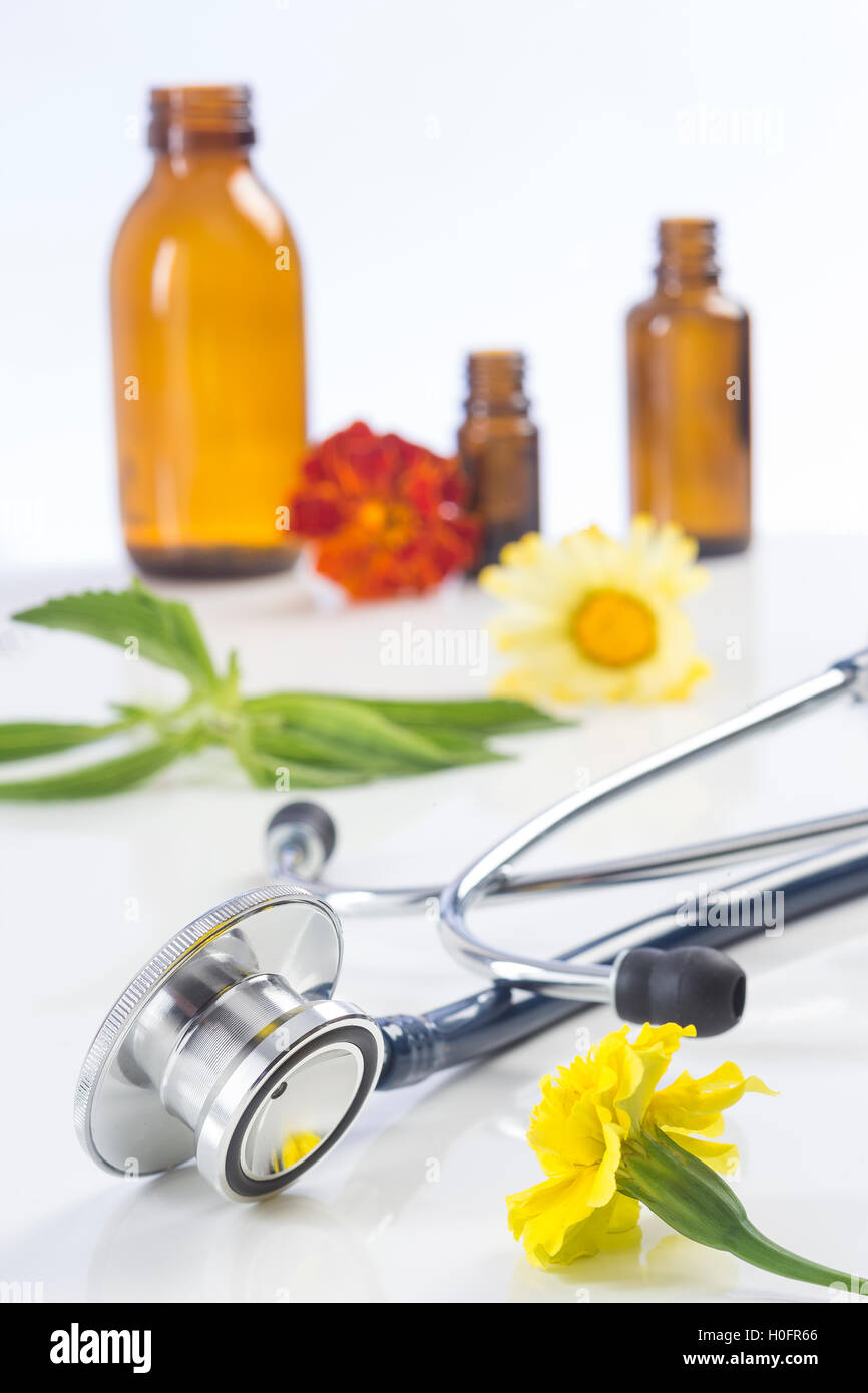 Bottiglia di olio essenziale di piante medicinali e uno stetoscopio Foto Stock