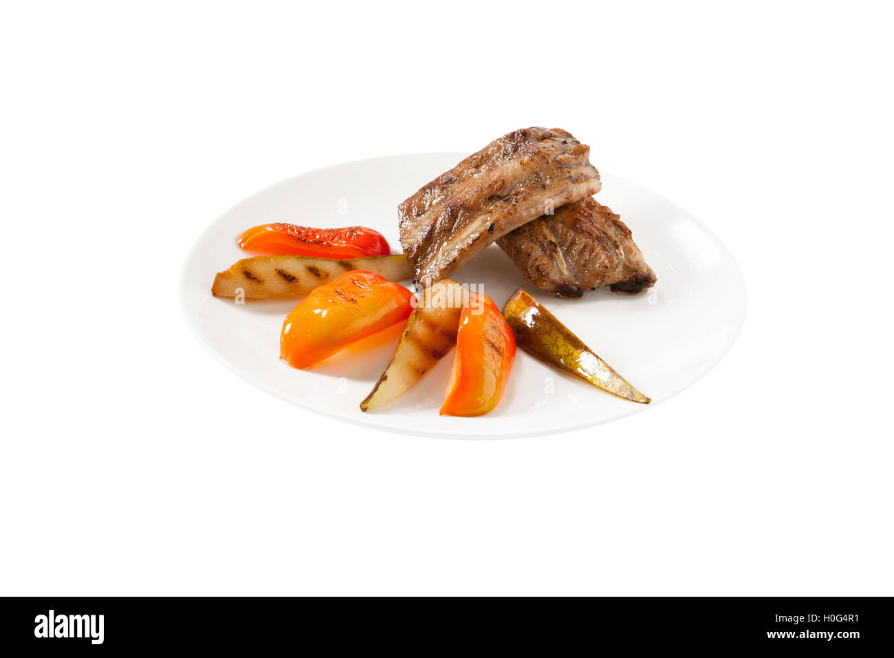 Costolette di maiale con pera e peperone su sfondo bianco Foto Stock