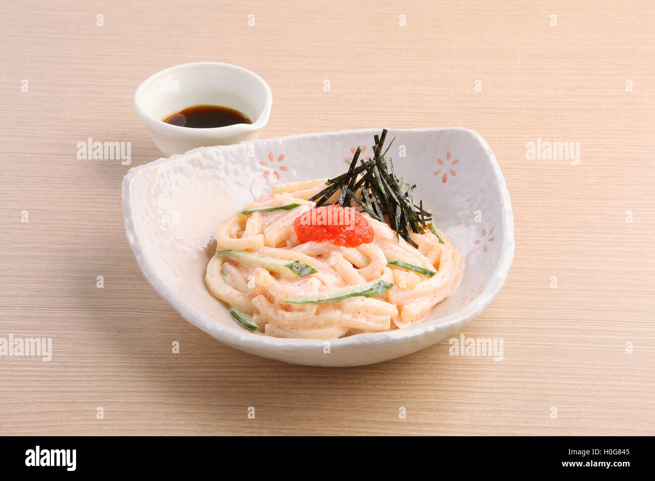 A base di noodle giapponesi di Hakata Mentai Mayo Udon con salsa soyal sul tavolo di legno Foto Stock