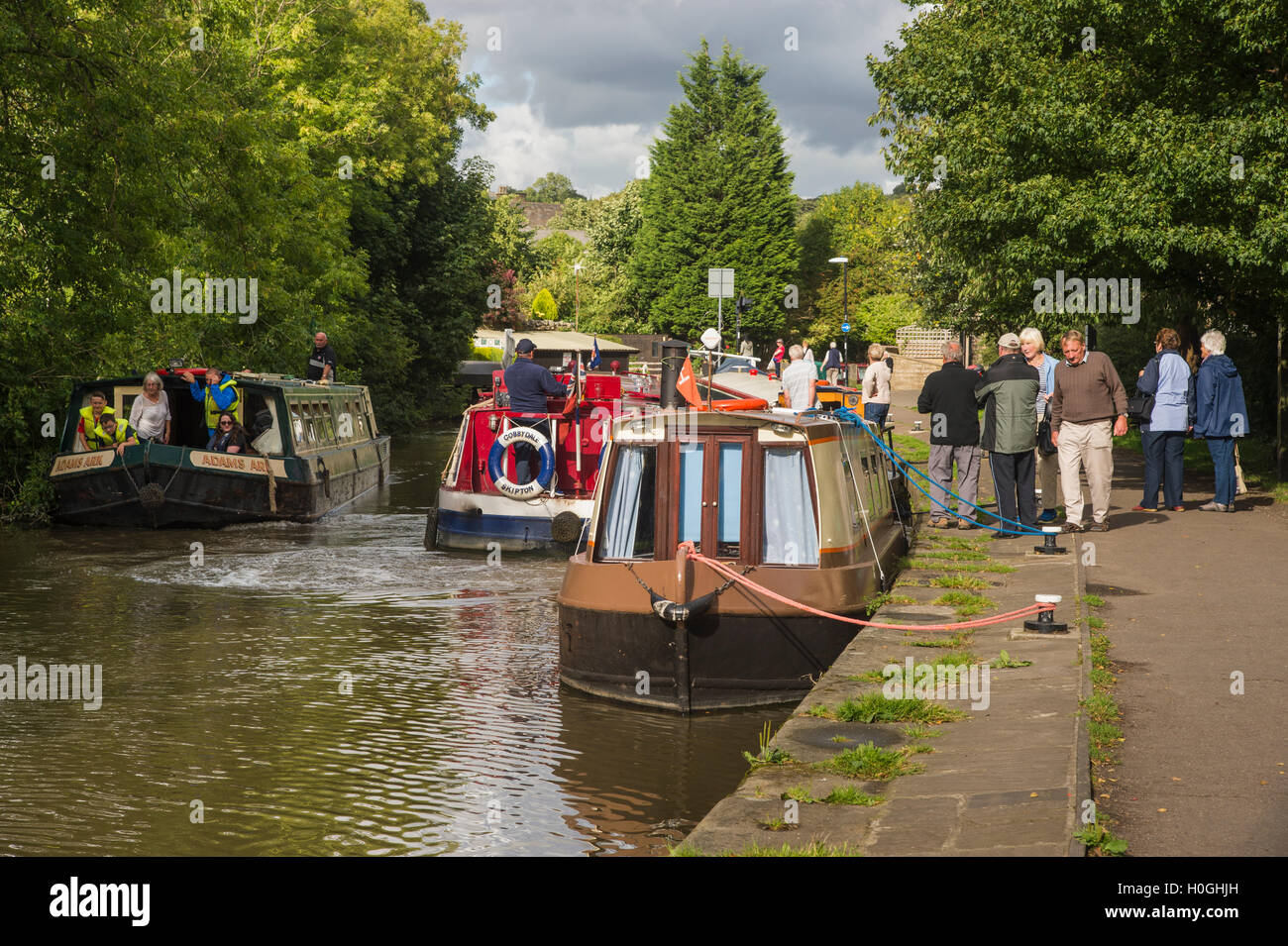 Tempo libero per le persone crociere su battelli o camminando sulla strada alzaia - canale Leeds-Liverpool, Skipton, North Yorkshire, GB. Foto Stock