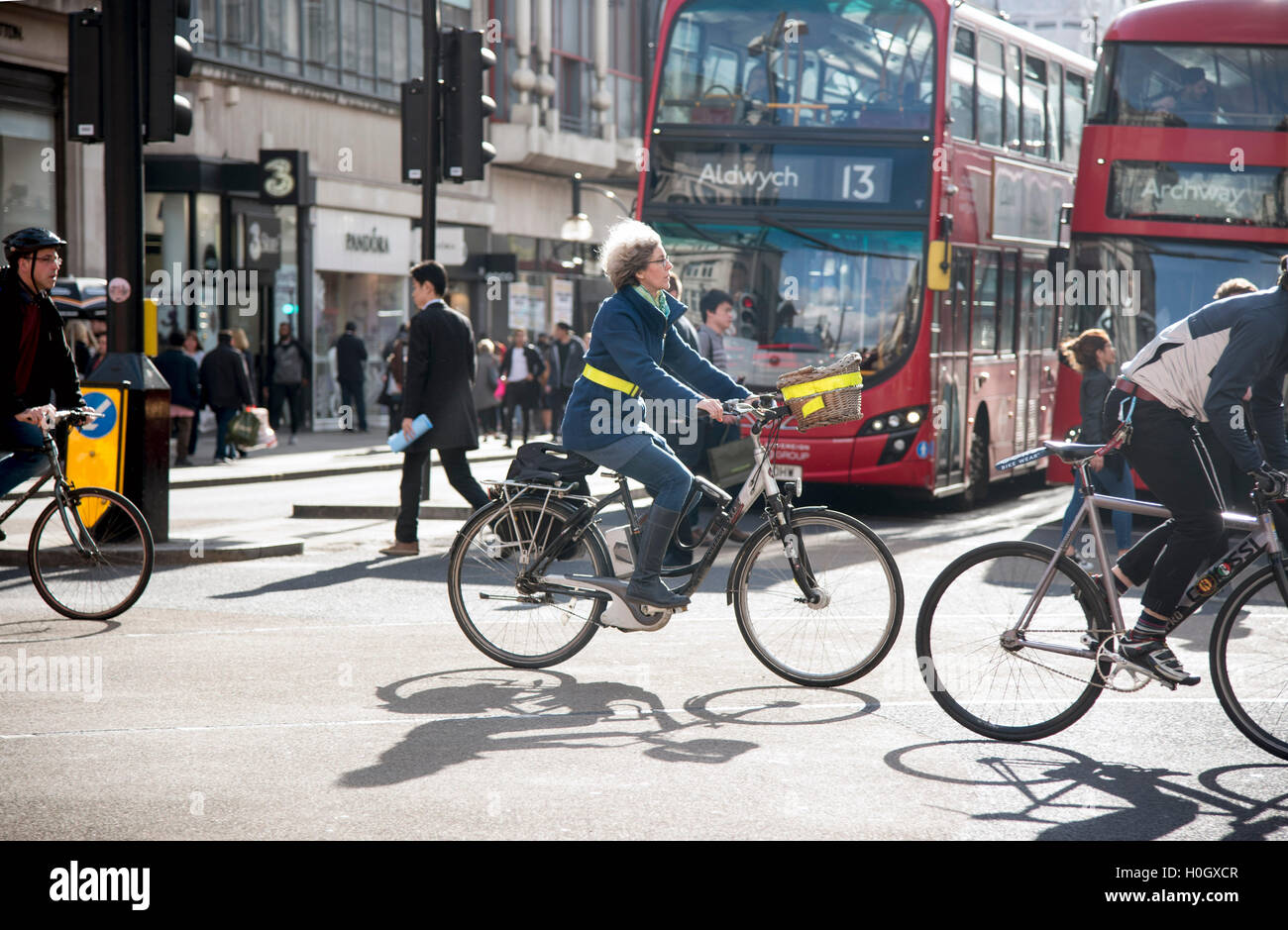 Donna anziana capelli grigi corse in bicicletta bici junction Foto Stock