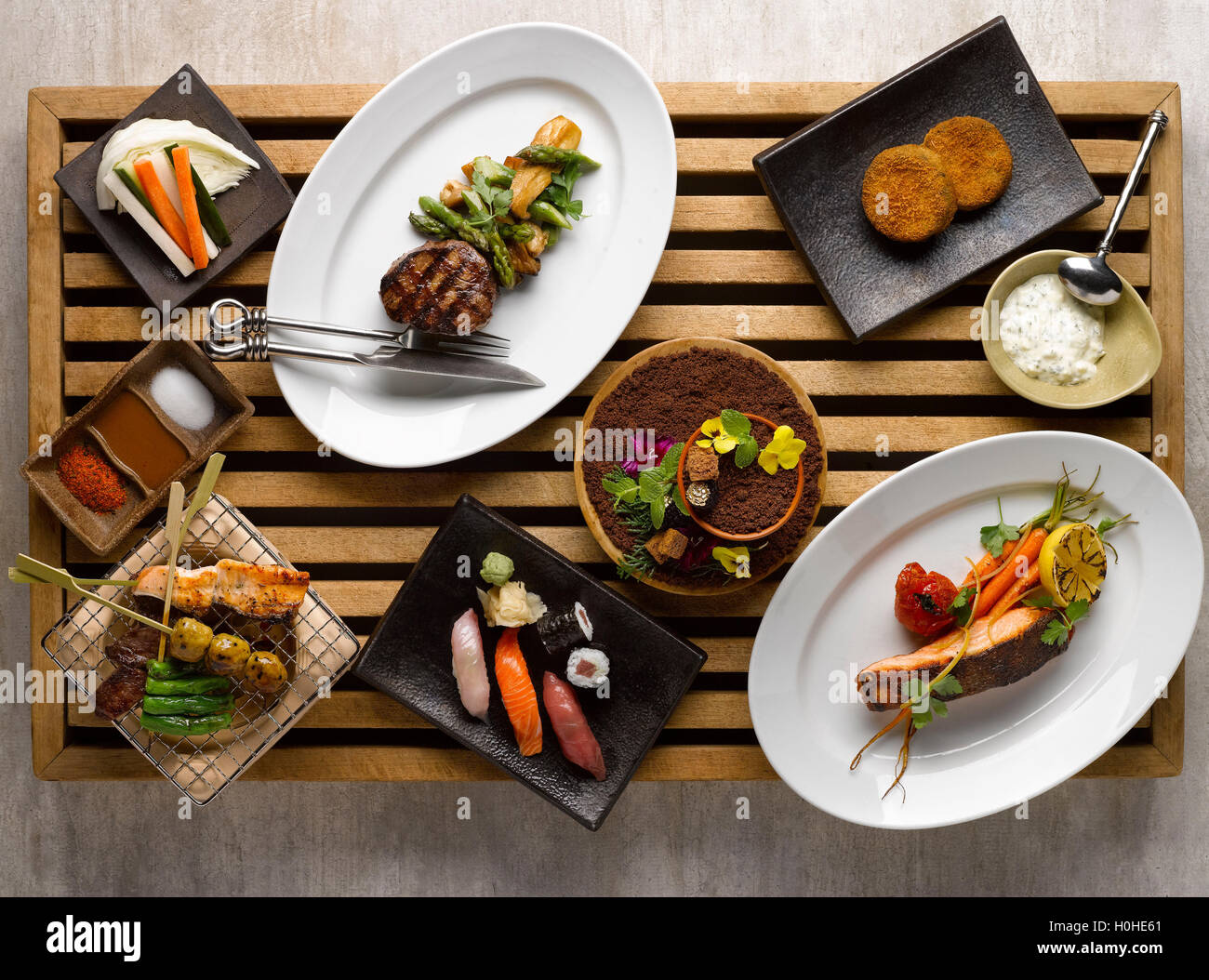 Cena giapponese insieme mezza con sushi, arrosto di manzo, snapper, verdure sul vassoio in legno Foto Stock