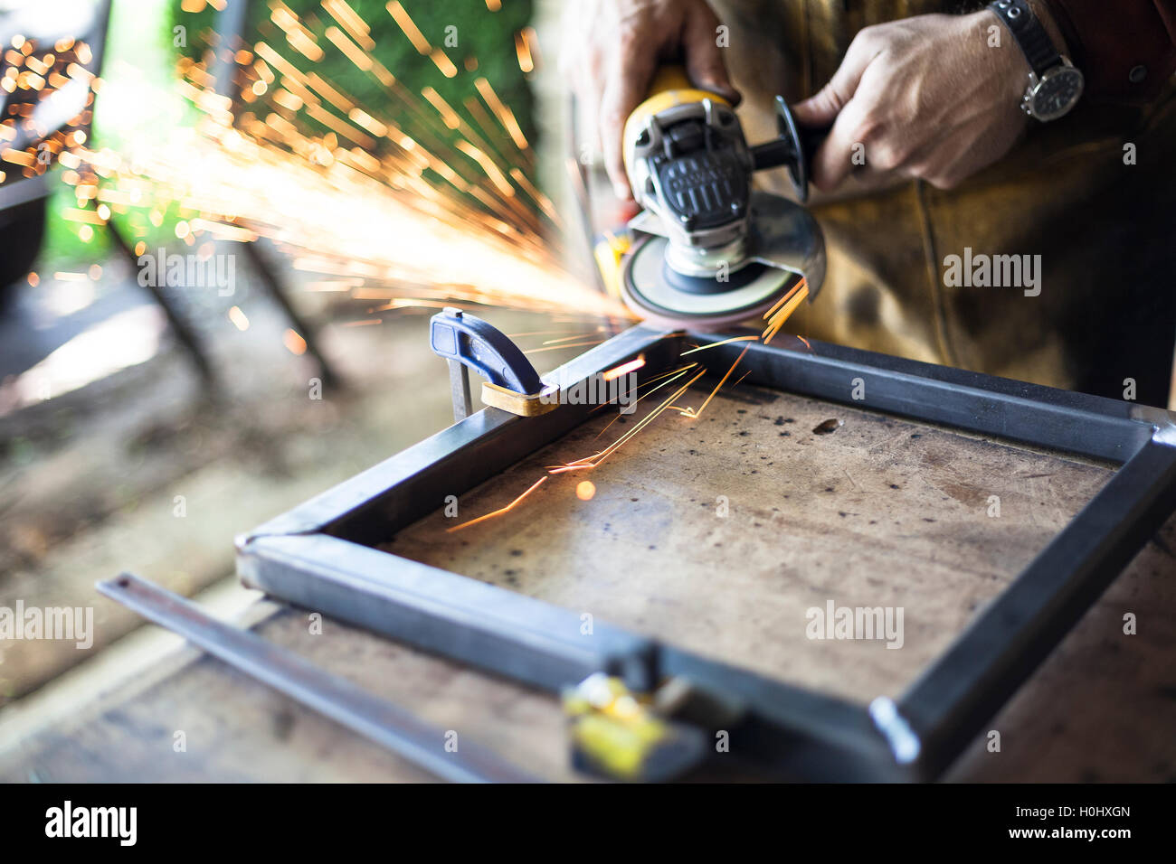 Arredamento personalizzato lavoratore grind giunzioni di saldatura su acciaio. Foto Stock