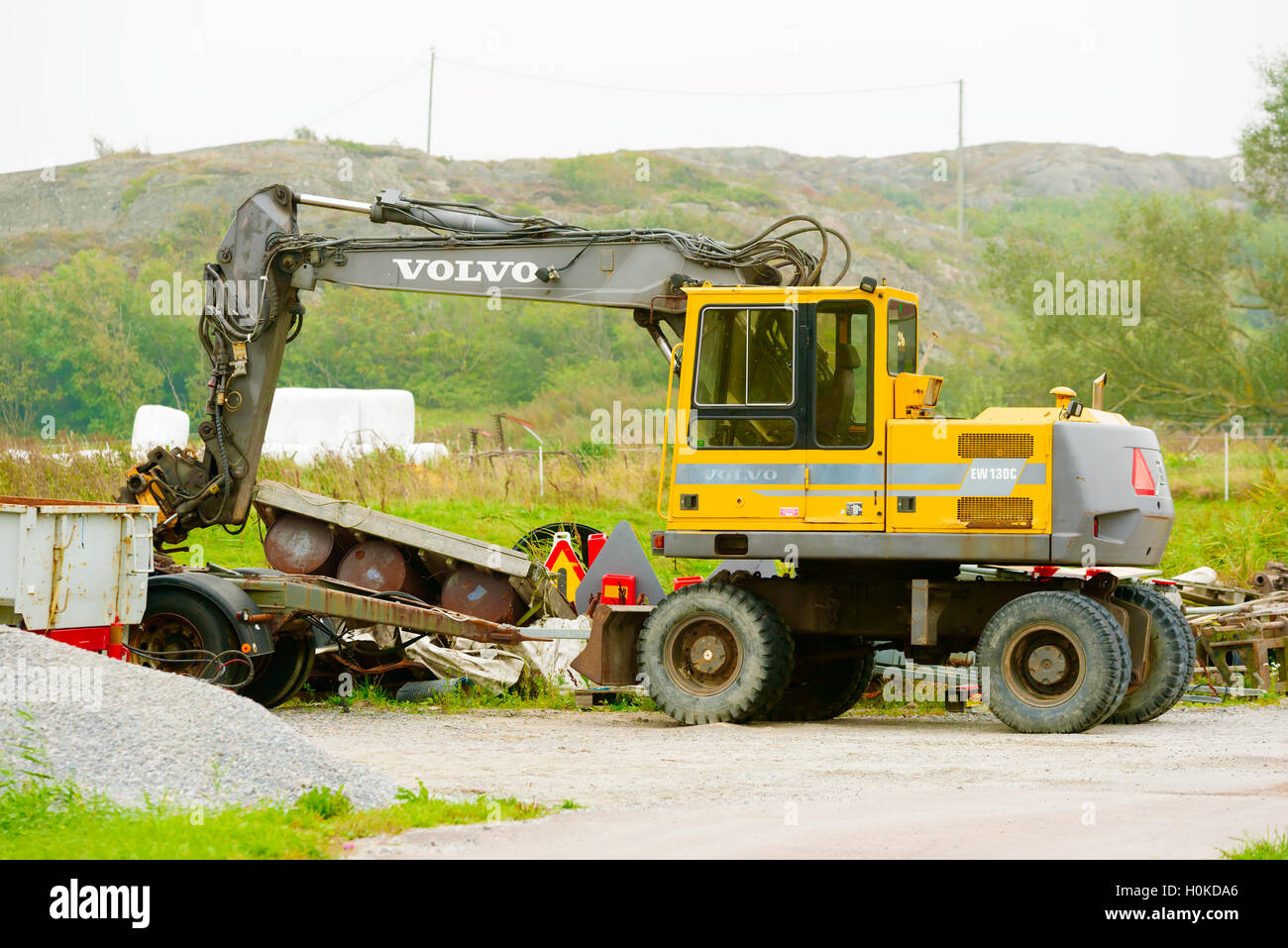 Tjorn, Svezia - 9 Settembre 2016: ambientale documentario di un giallo Volvo EW130C Escavatore in brumoso paesaggio. Foto Stock