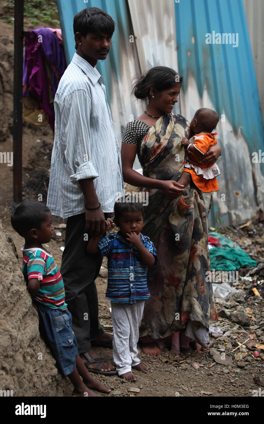 Una povera famiglia indiana di padre e madre di tre bambini in piedi presso il cantiere lavorano a. Foto Stock