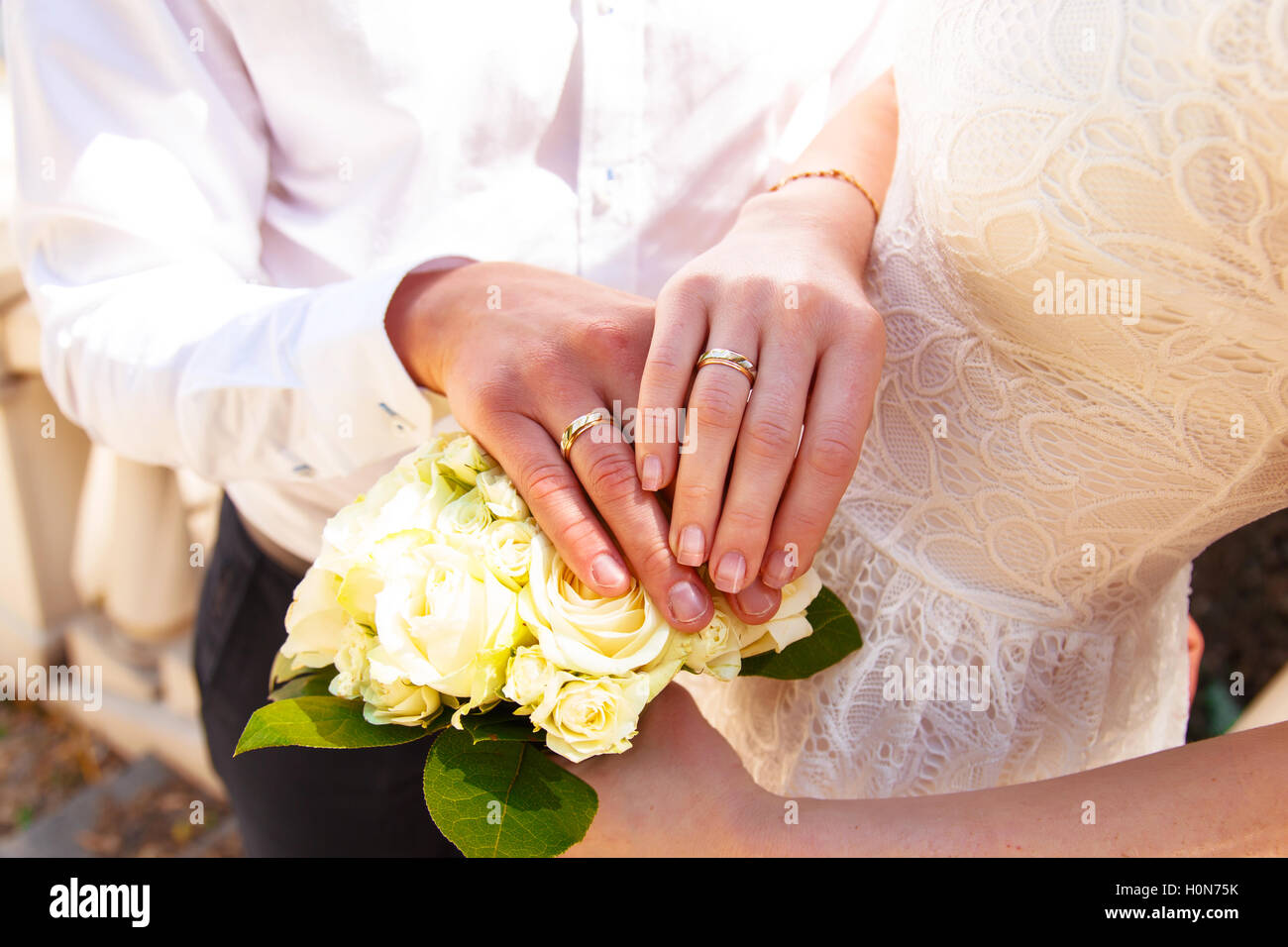 Le mani e gli anelli sul mazzo di nozze close up Foto Stock