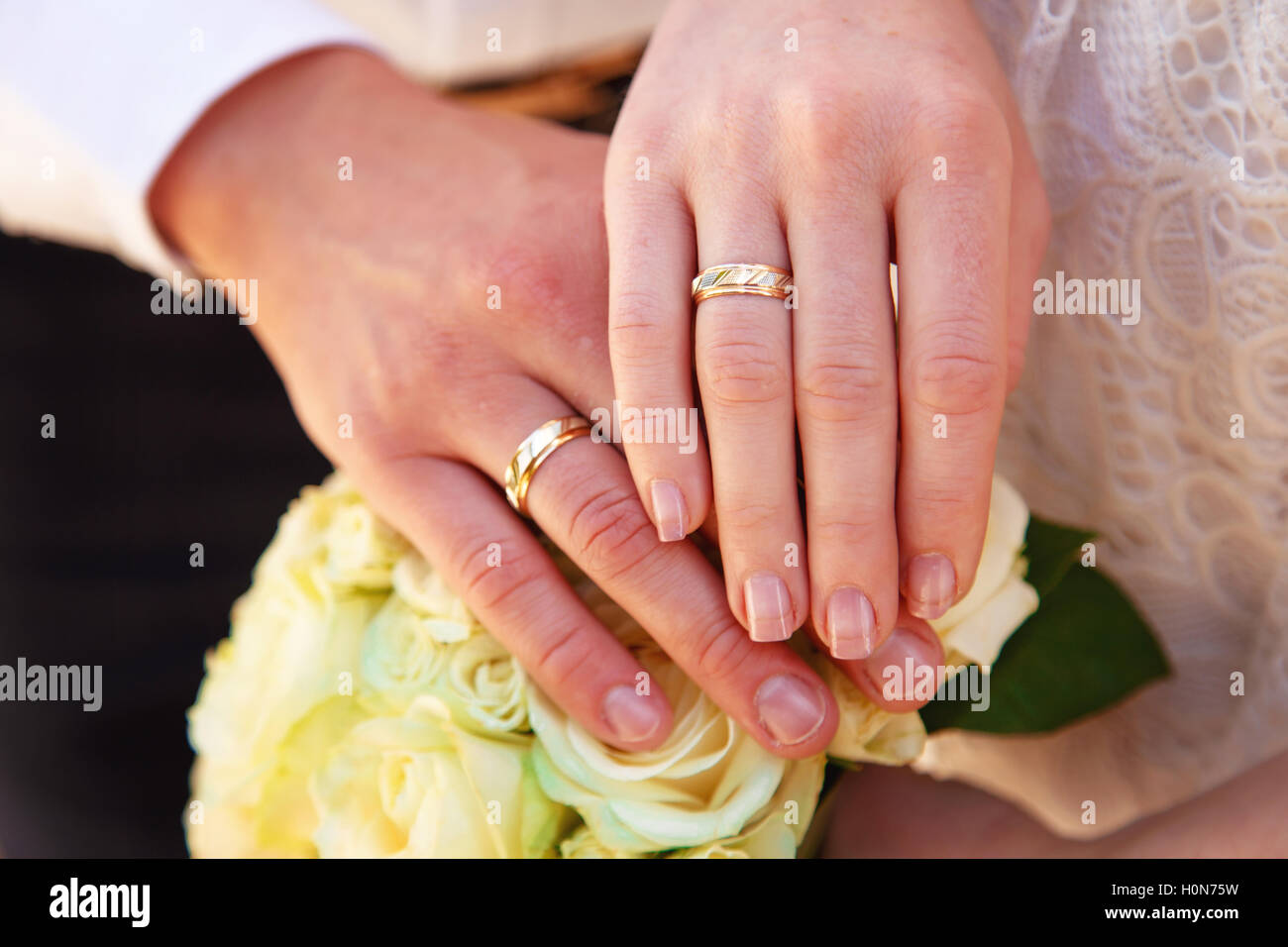Le mani e gli anelli sul mazzo di nozze close up Foto Stock