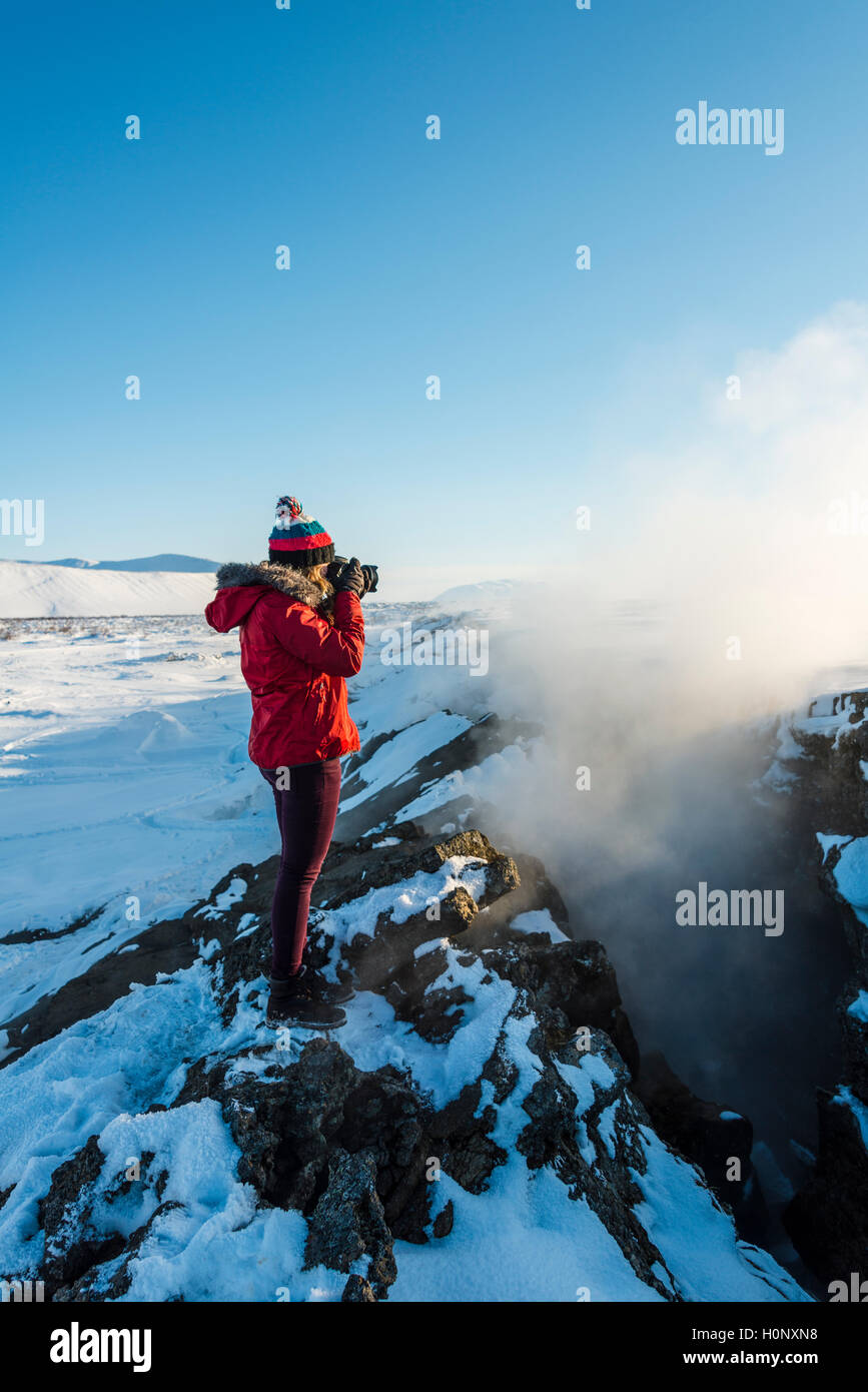 Donna in piedi a tettonica divergenti di confine tra Nord America e piastre eurasiatica, fotografando, Mid-Atlantic Ridge Foto Stock