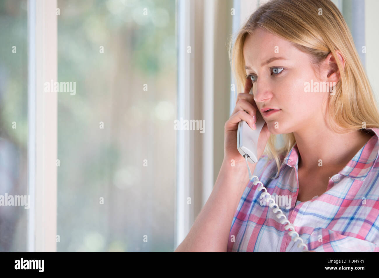 Ansioso giovane donna telefonare Helpline Foto Stock