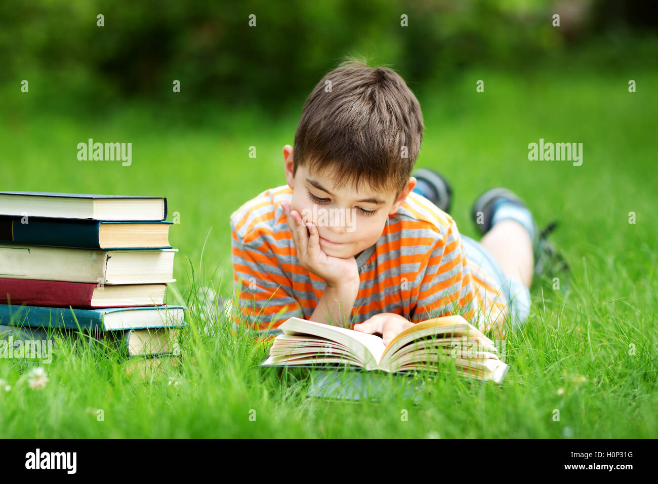 A sette anni di età bambino la lettura di un libro Foto Stock