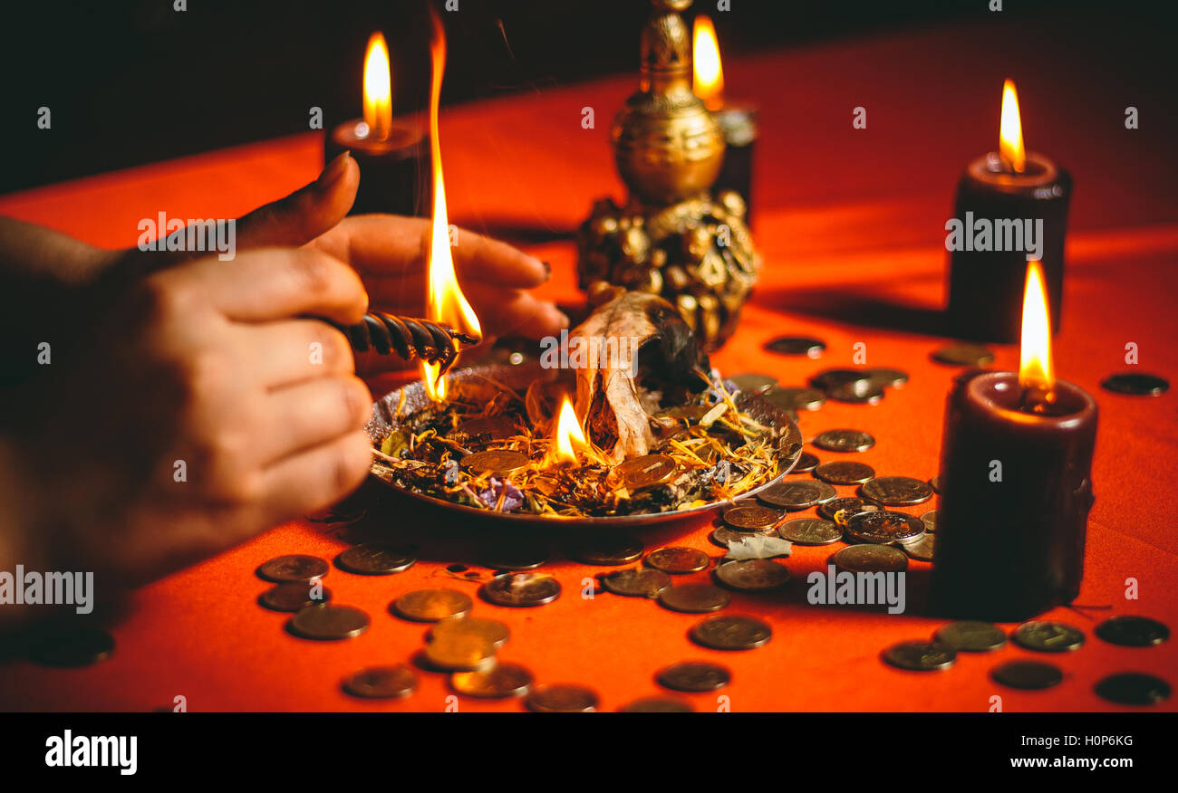 Una strega detiene un rituale per denaro Foto Stock
