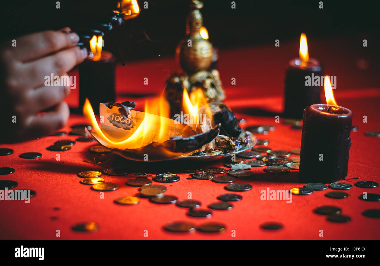 Una strega detiene un rituale per denaro Foto Stock
