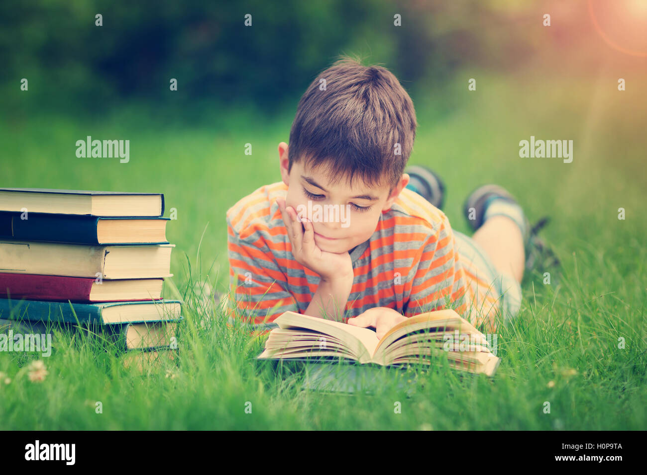 A sette anni di età bambino la lettura di un libro Foto Stock