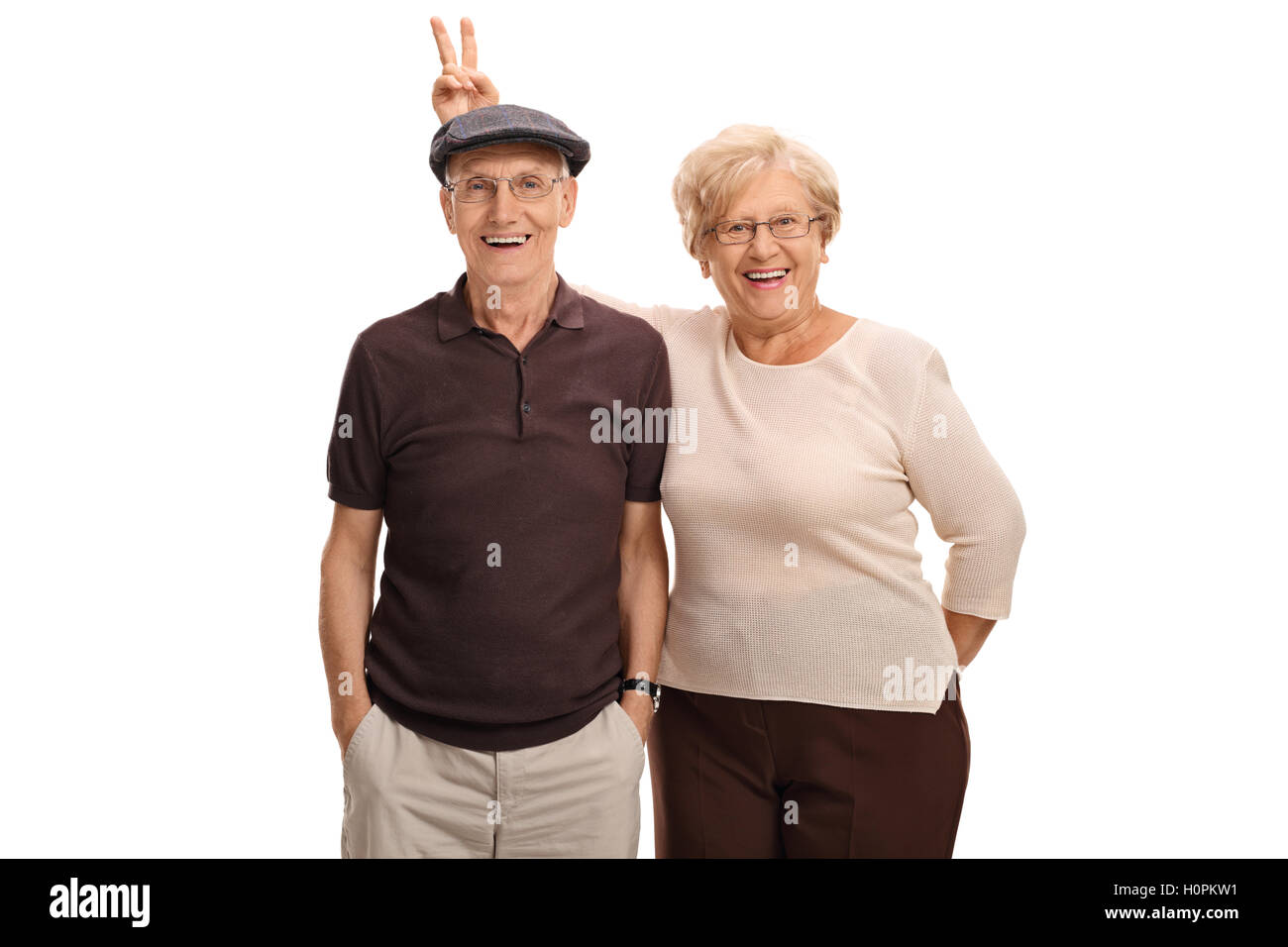 Donna anziana pranking suo marito con orecchie di coniglietto isolati su sfondo bianco Foto Stock