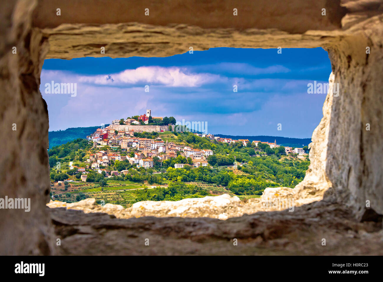 Città di Motovun sulla pittoresca collina di Istria attraverso la finestra di pietra, Croazia Foto Stock