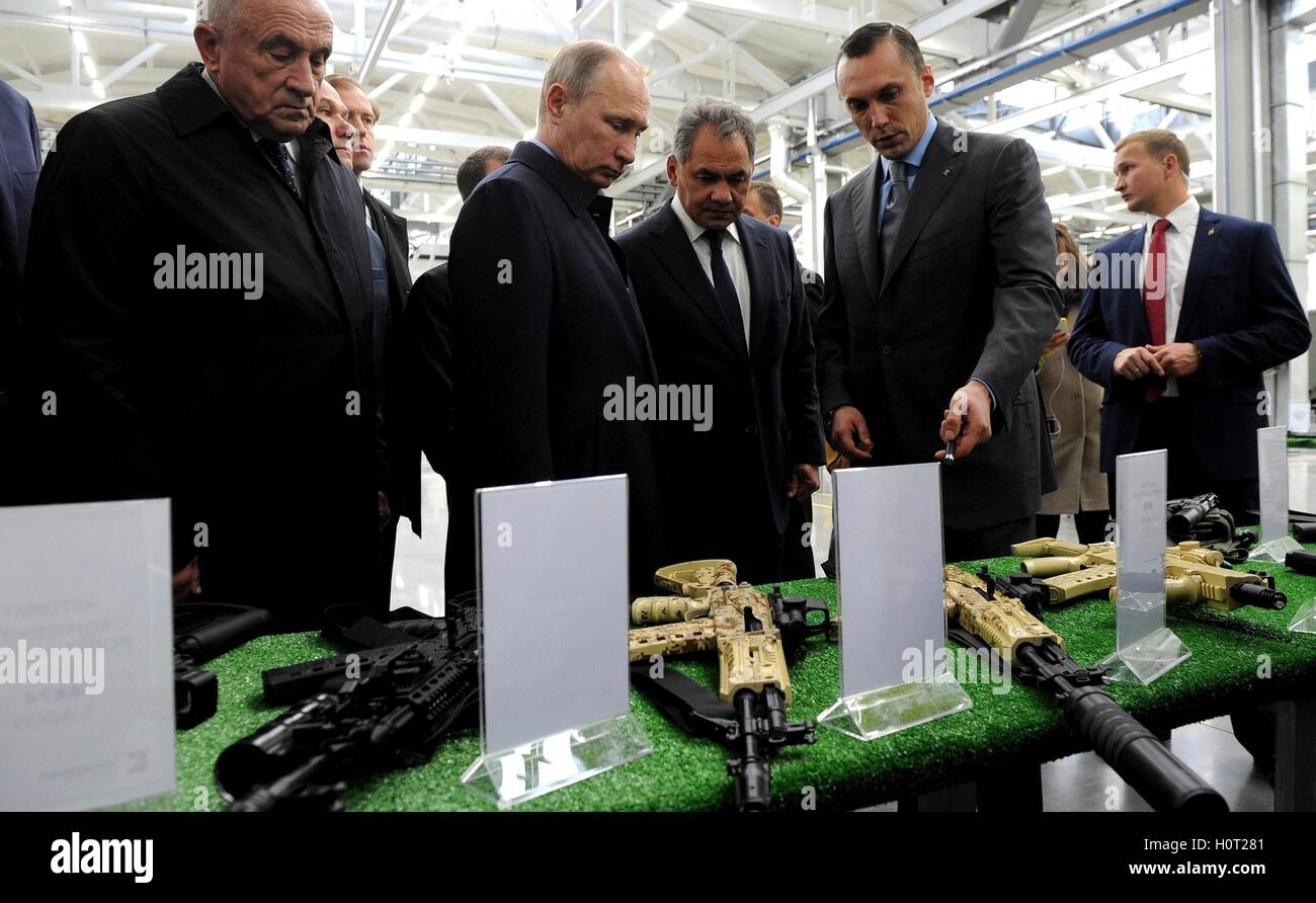 Il presidente russo Vladimir Putin ha accompagnato dal ministro della Difesa Sergei Shoigu, centro, viste le armi prodotte dal Kalashnikov preoccupazione durante una visita alla fabbrica di Settembre 20, 2016 in Izhevsk, Russia. Kalashnikov è il più grande produttore di armi in Russia. Foto Stock