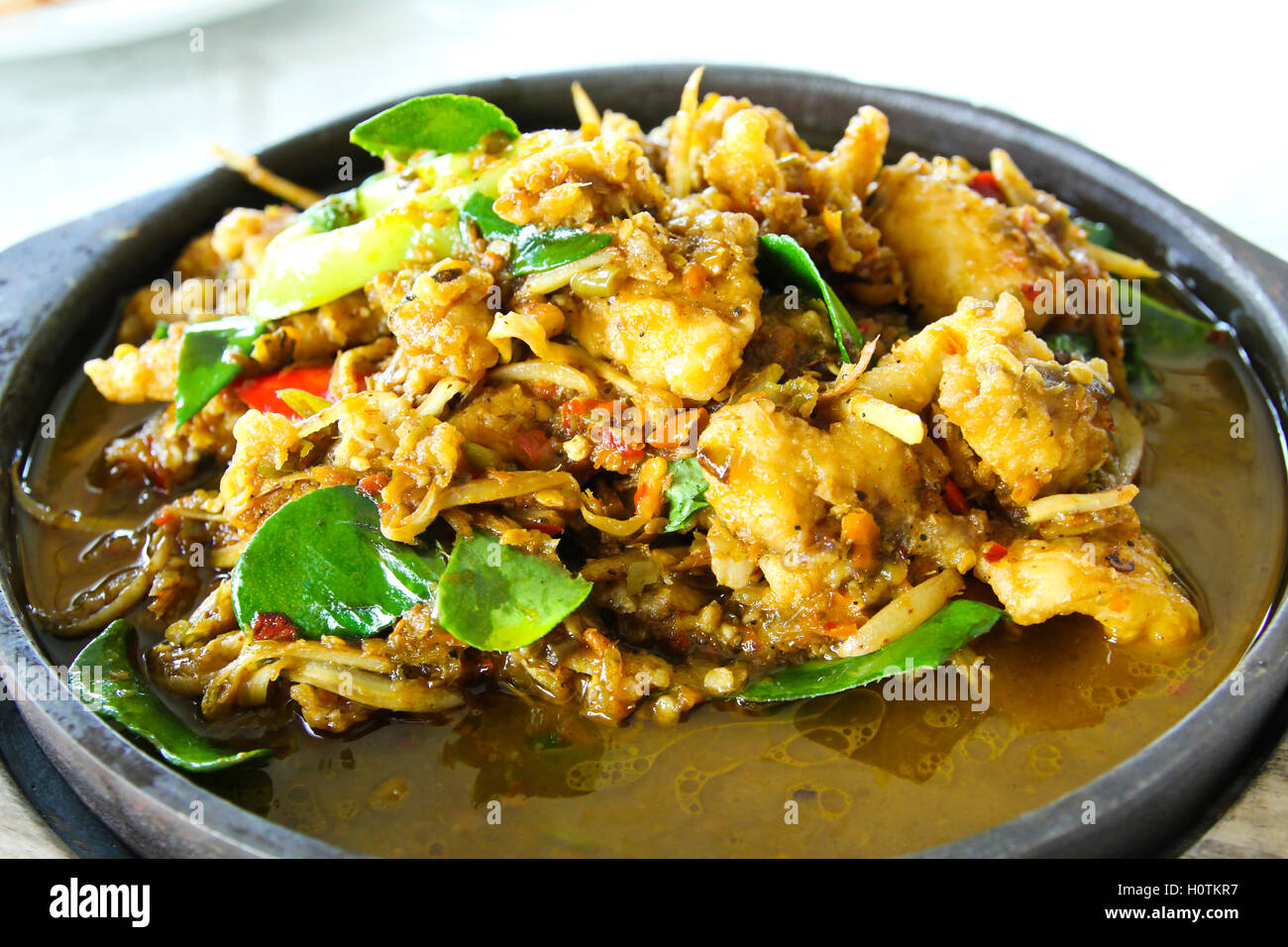 Mescolare frittura di pesce gatto gigante sulla piastra calda Foto Stock