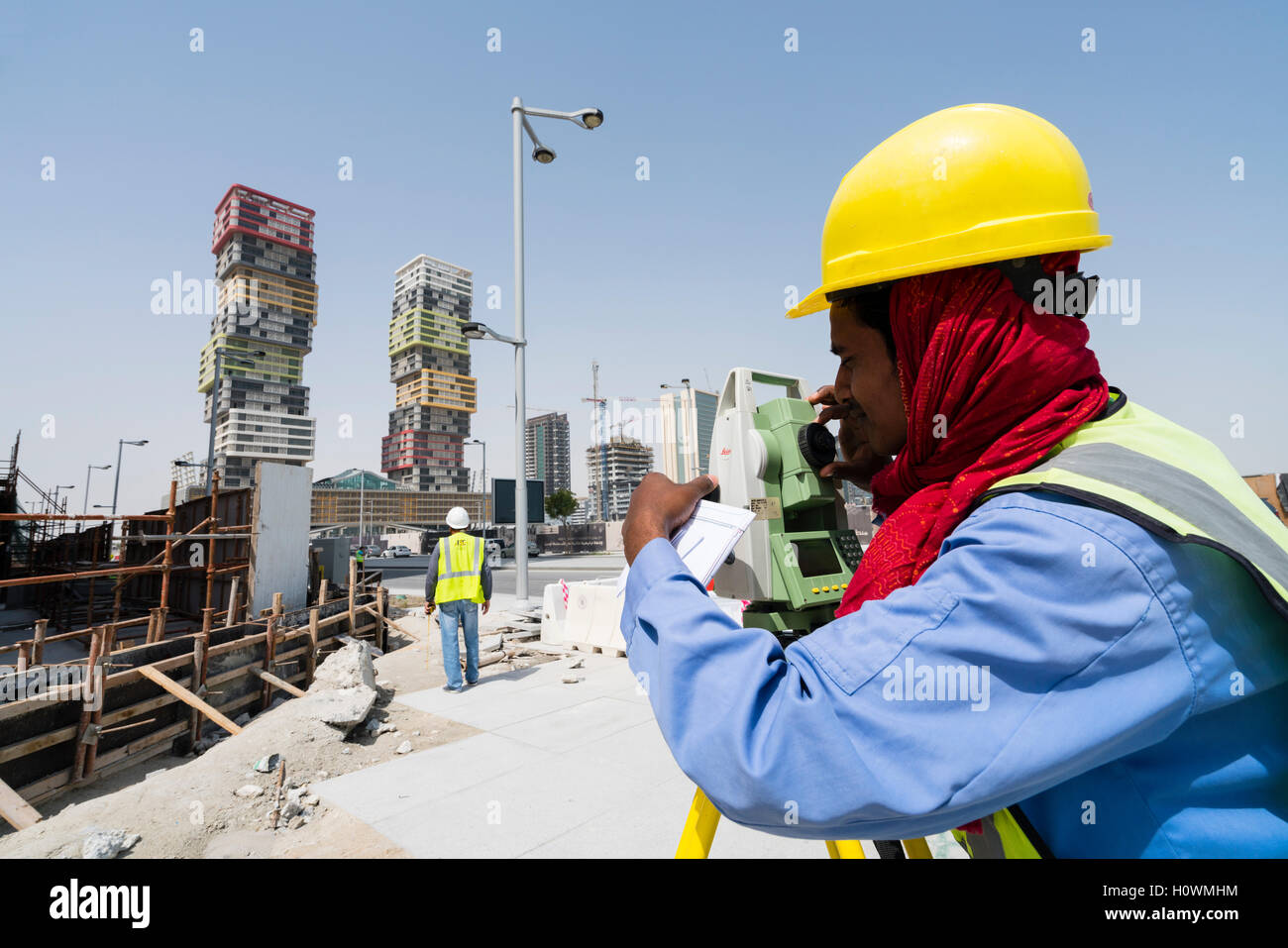 Operaio edile utilizzando teodolite a Lusail Città nuova proprietà lo sviluppo di Doha, in Qatar Foto Stock