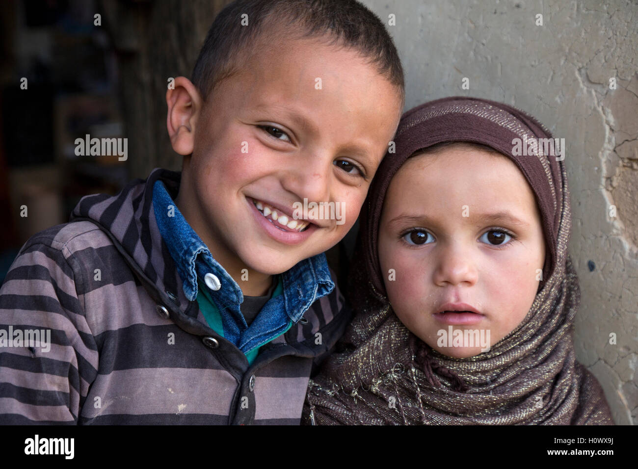 Dades Gorge, Marocco. Giovane berbero fratello e sorella in piedi dalla loro porta. Foto Stock