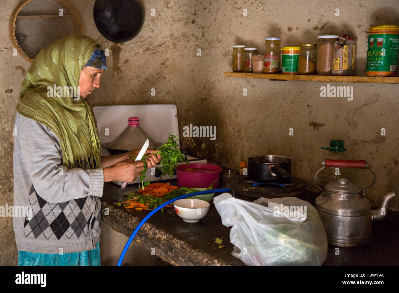 Dades Gorge, Marocco. Di mezza età donna berbera prepara la cena nella sua cucina. Foto Stock