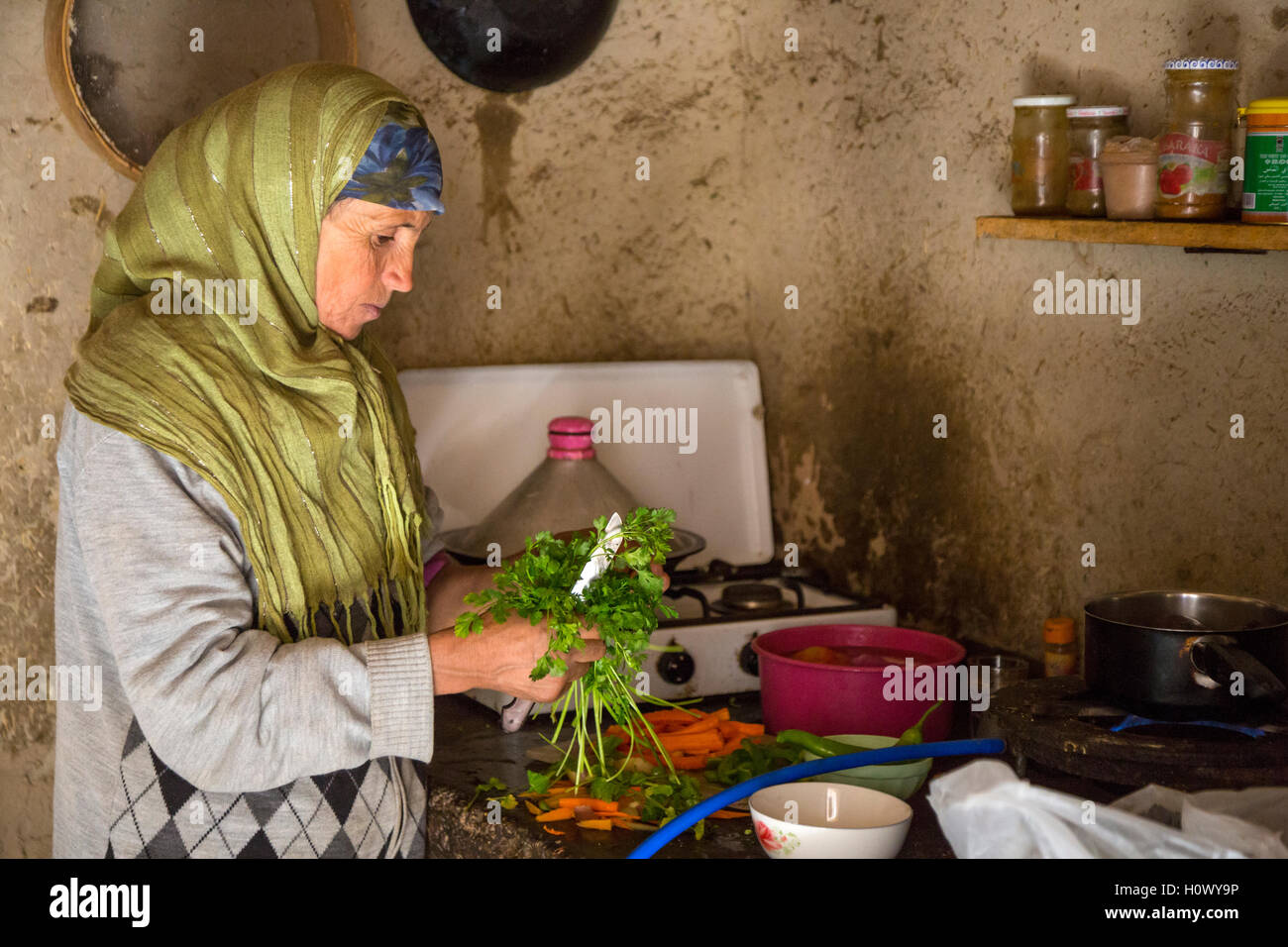 Dades Gorge, Marocco. Di mezza età donna berbera prepara la cena nella sua cucina. Foto Stock