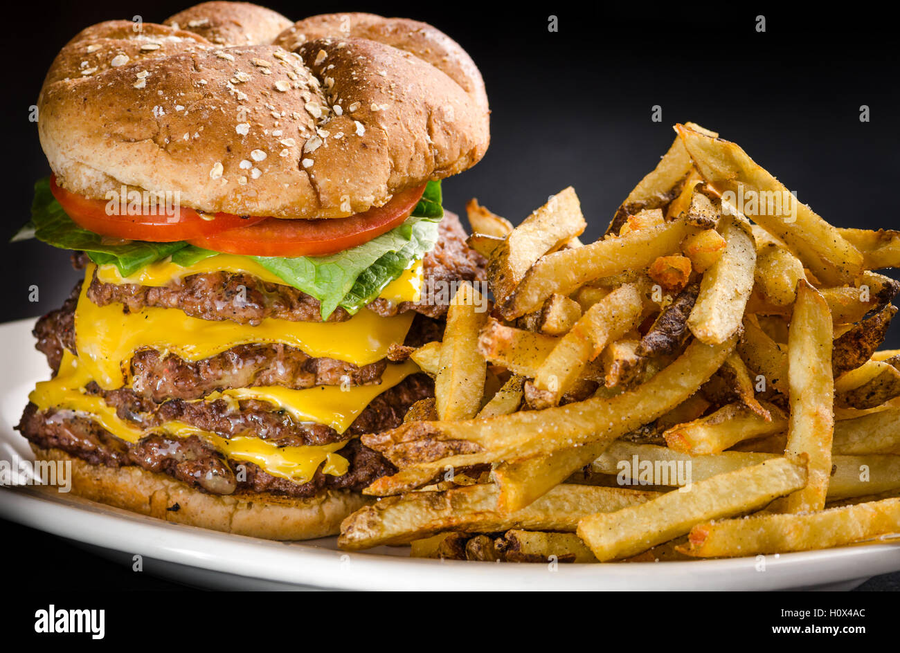 Attacco di cuore su un bun, una sterlina cheeseburger con patate fritte Foto Stock