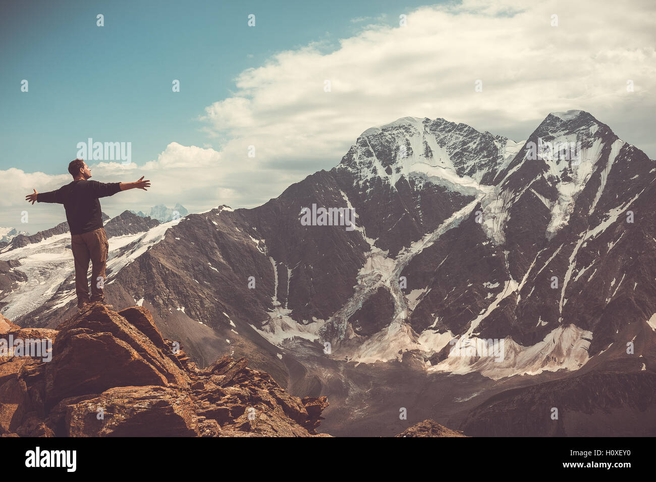 L'uomo sulla cima della collina guardando lo splendido paesaggio delle montagne del Caucaso in Russia, Kabardino-Balkaria Foto Stock