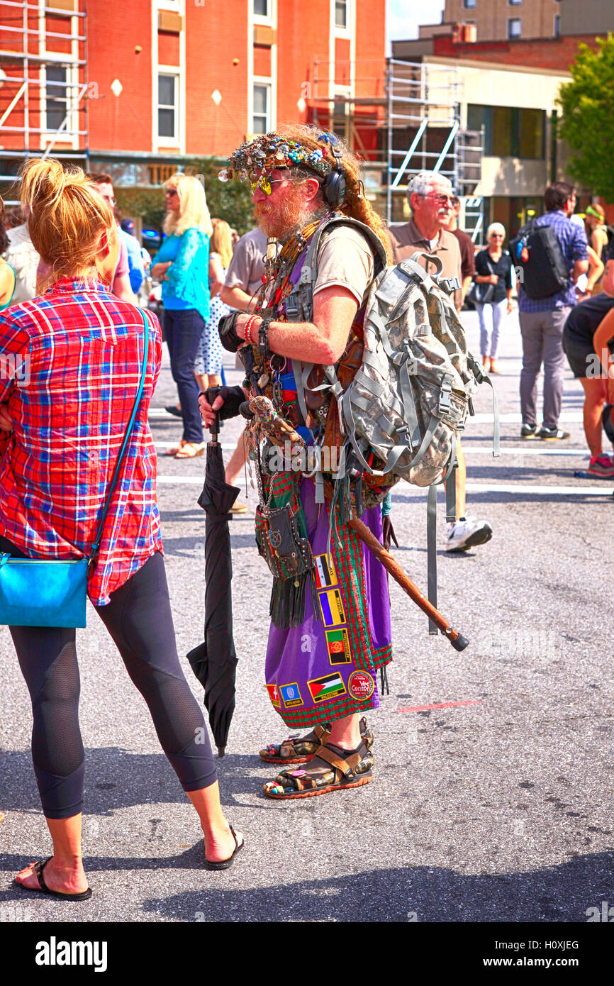 Invecchiamento hippy di uomo in piedi con l'anti-Trump sostenitori in Asheville NC Foto Stock