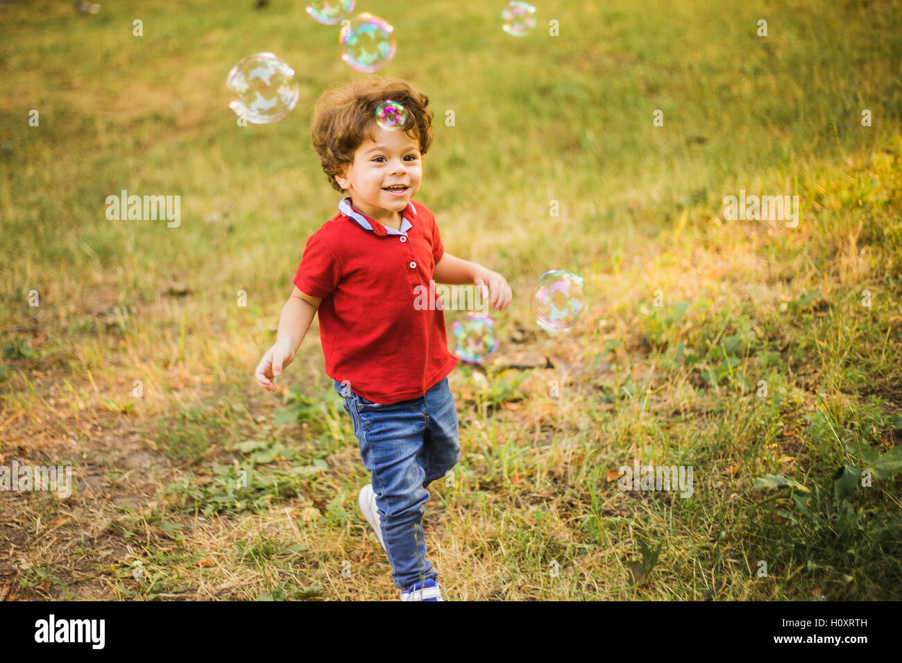 Little Boy giocano nel parco con bolle Foto Stock