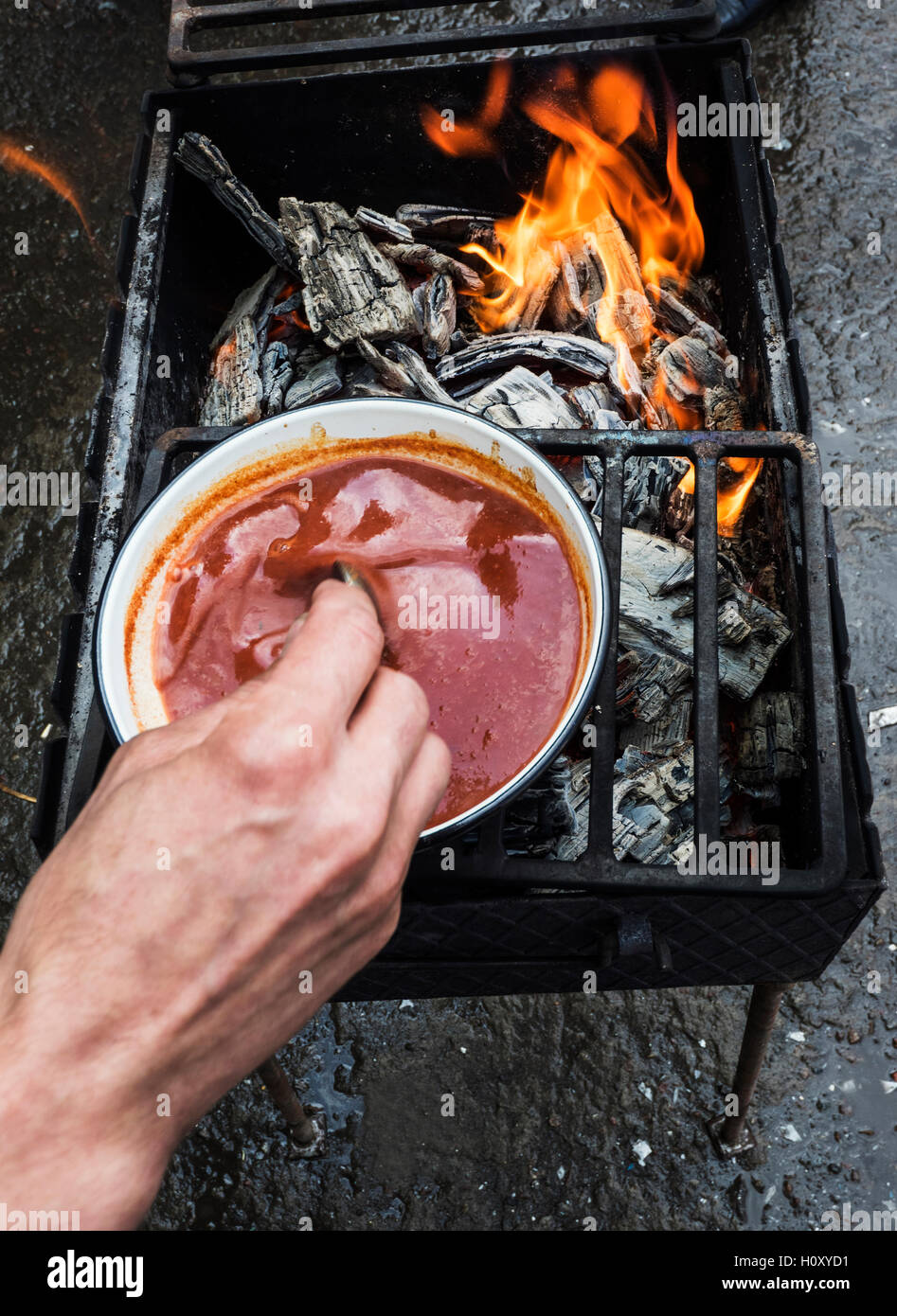 L'uomo la preparazione sul grill la salsa di pomodoro per la carne alla brace Foto Stock