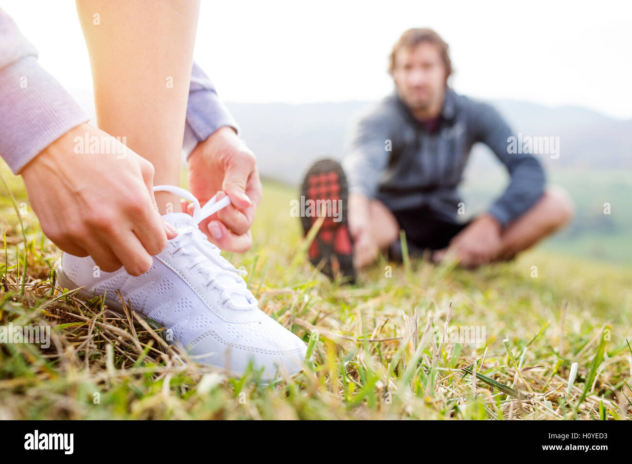 Matura in esecuzione in autunno la natura, stretching, legatura lacci delle scarpe Foto Stock