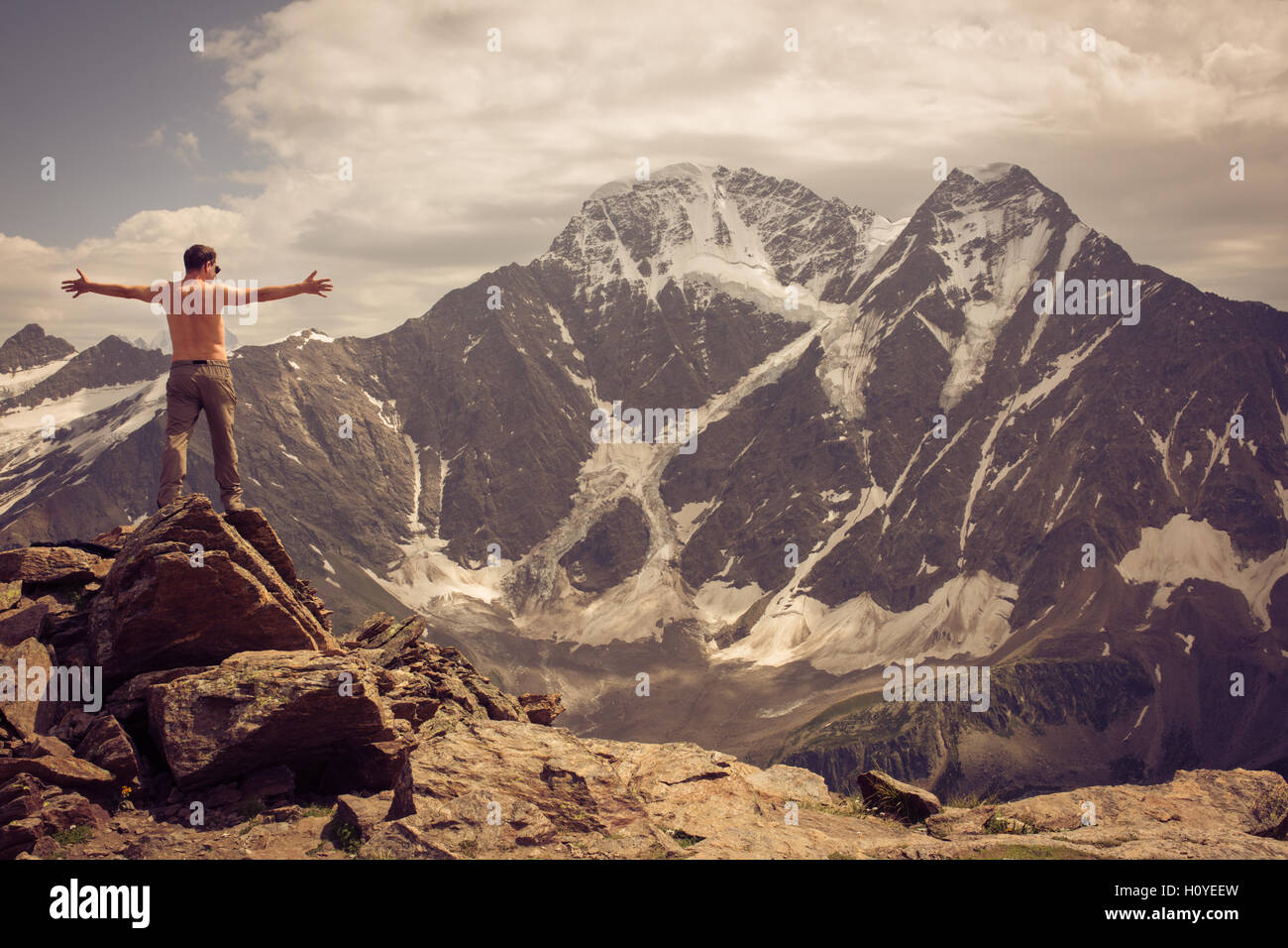 L'uomo sulla cima della collina guardando lo splendido paesaggio delle montagne del Caucaso in Russia, Kabardino-Balkaria Foto Stock