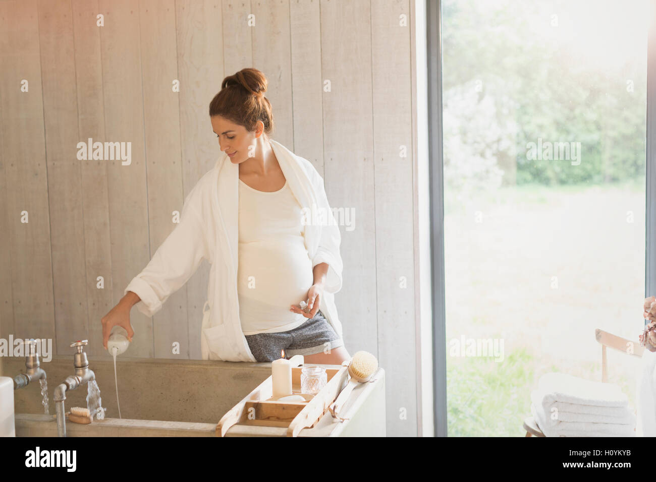 Donna incinta preparazione bubble bath Foto Stock