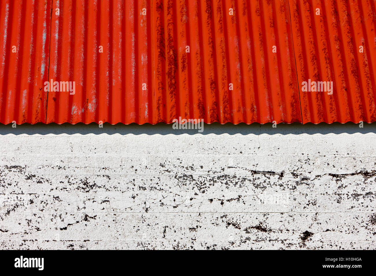 Dipinto di rosso metallo ondulato tetto su una farm annesso in Islanda Foto Stock