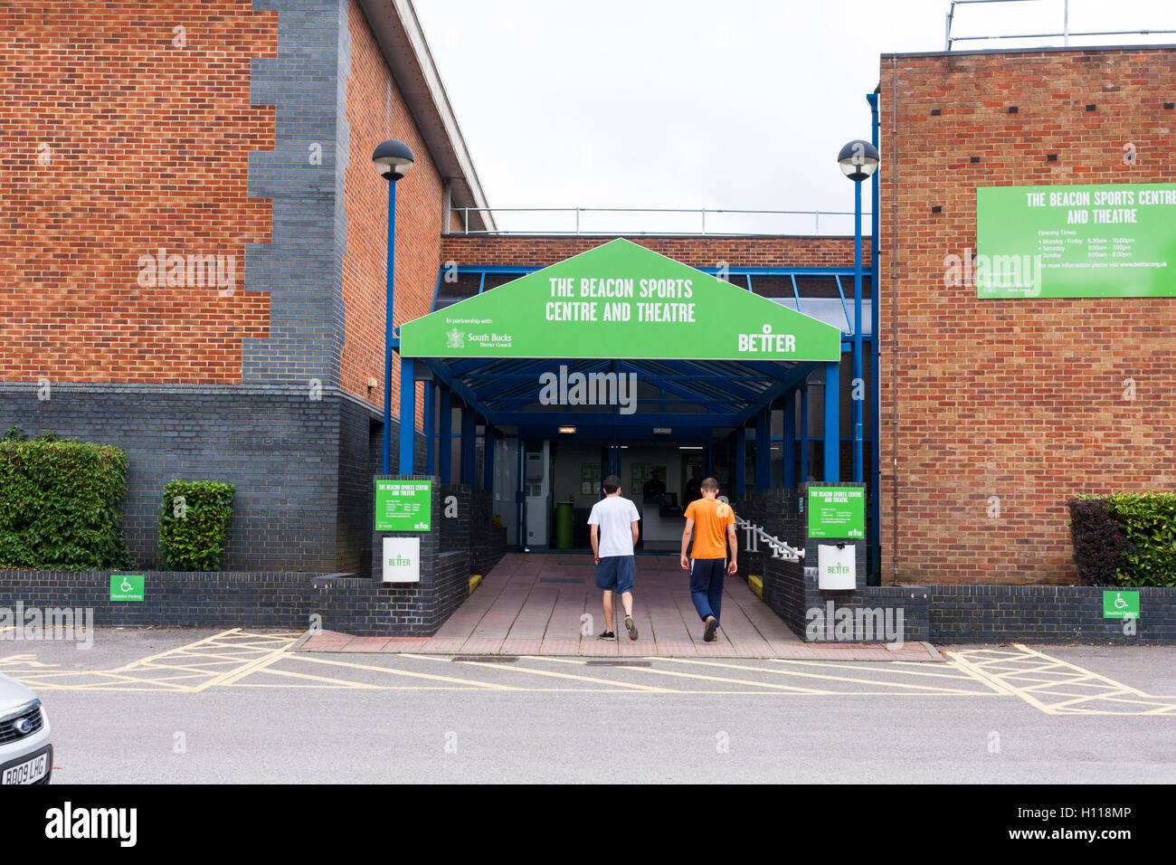 Due maschi a piedi in entrata principale del faro rotante al centro sportivo, Beaconsfield, Buckinghamshire, UK Foto Stock