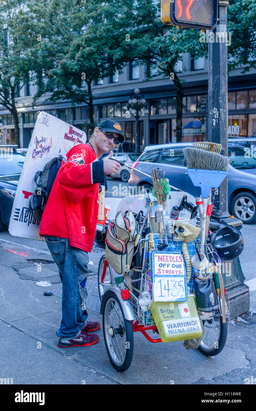 L'uomo pulisce gli aghi a sinistra su strade DTES, Vancouver, British Columbia, Canada, Foto Stock
