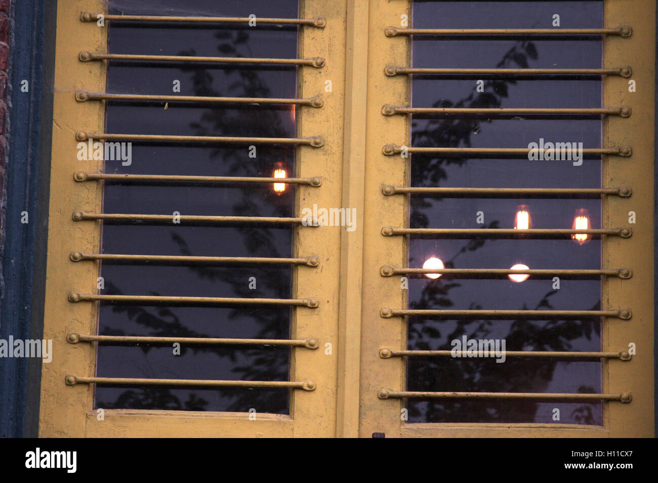 Vista delle lampadine della luce attraverso il metallo finestra alla griglia Foto Stock