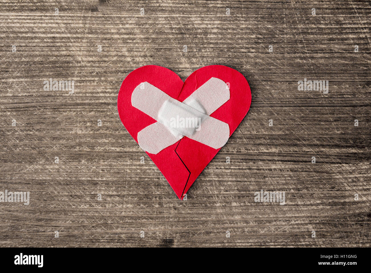 Cuore spezzato con gesso sul vecchio sfondo di legno Foto Stock